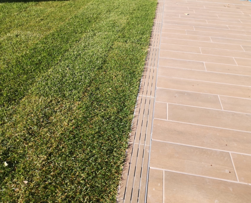 Detalle de césped y pavimento exterior de un jardín